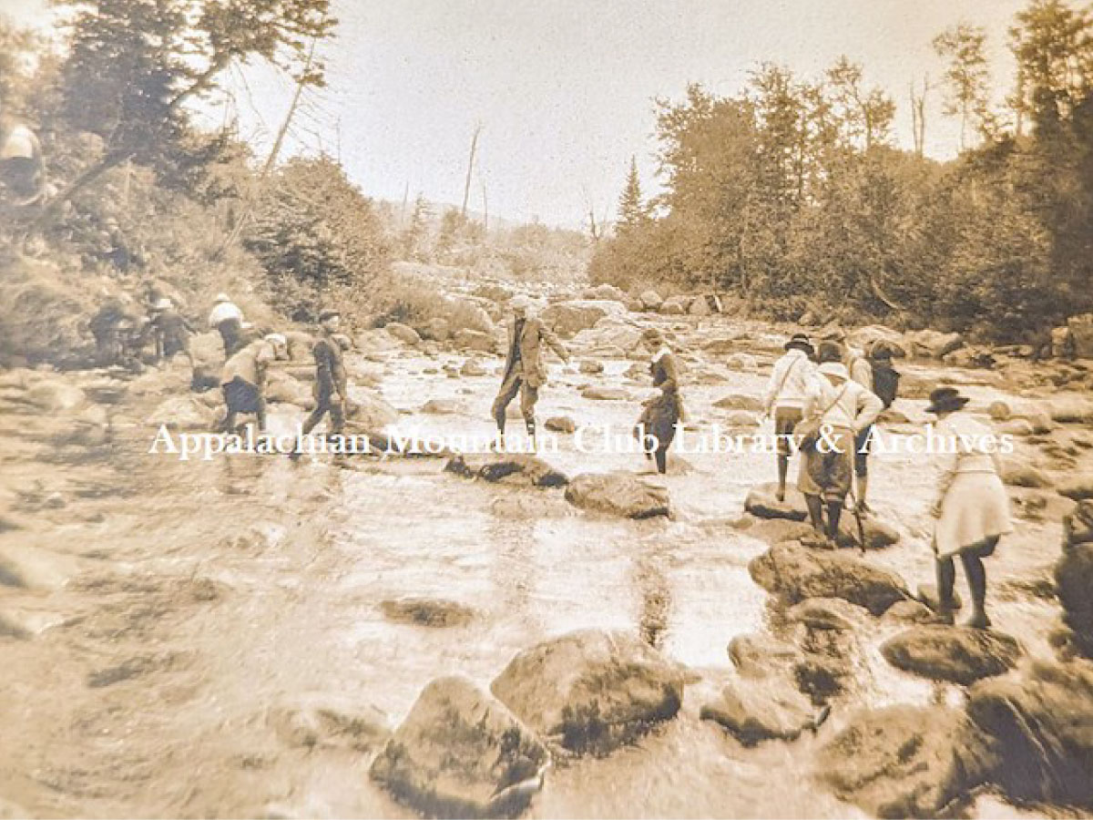 Hikers crossing a rocky stream