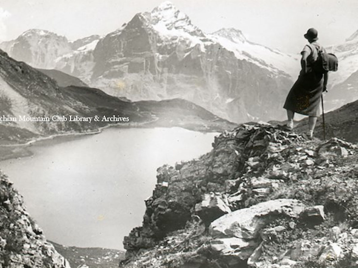 A female hiker looking out over a mountain lake