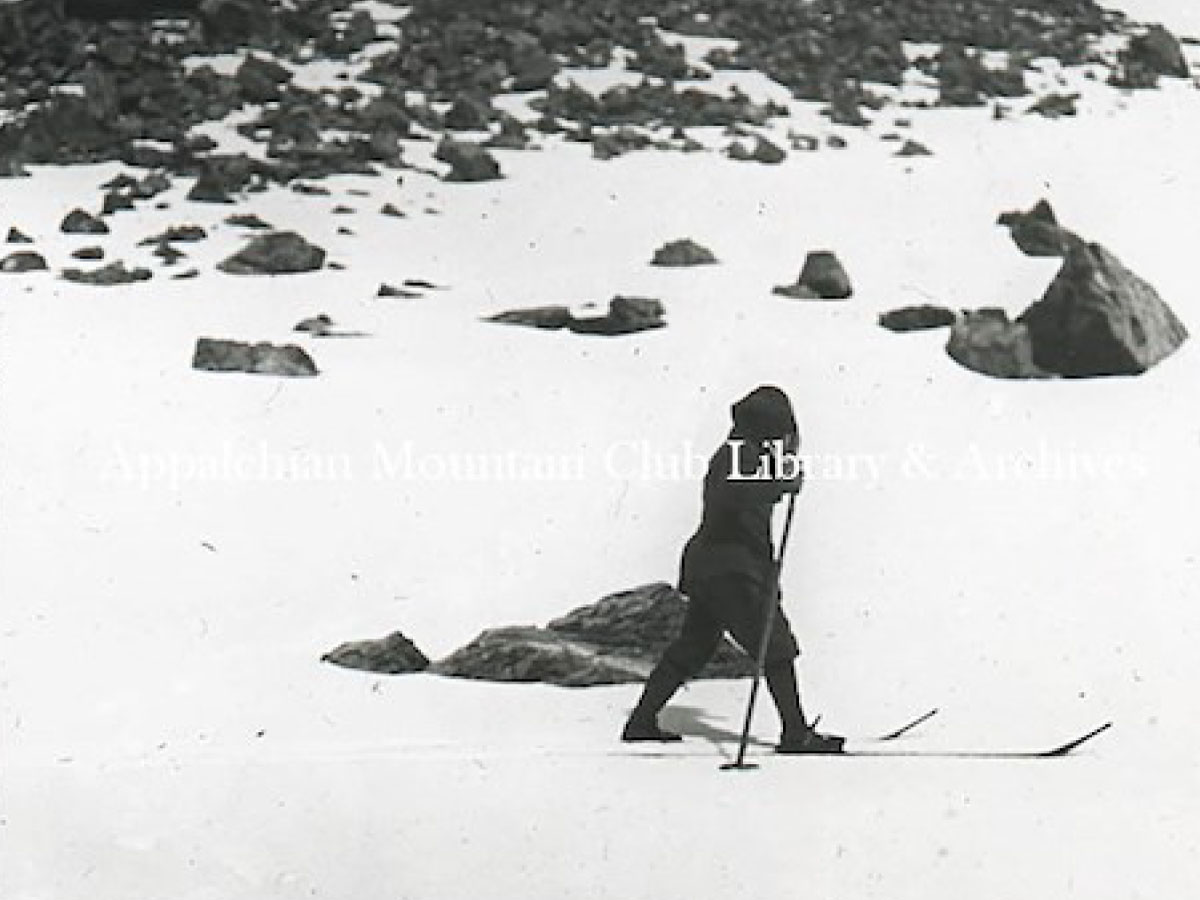A woman skiing across a snowfield