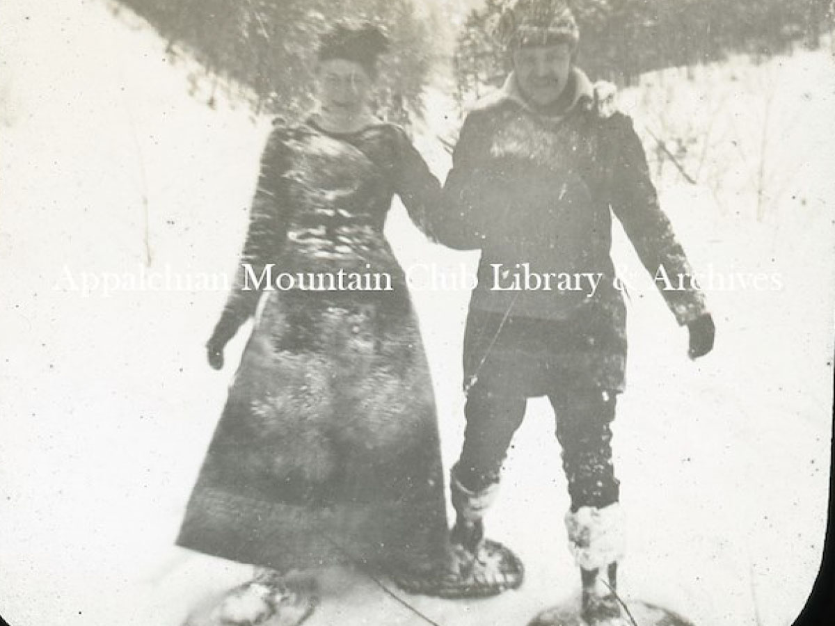 A man and woman walking together on three snowshoes