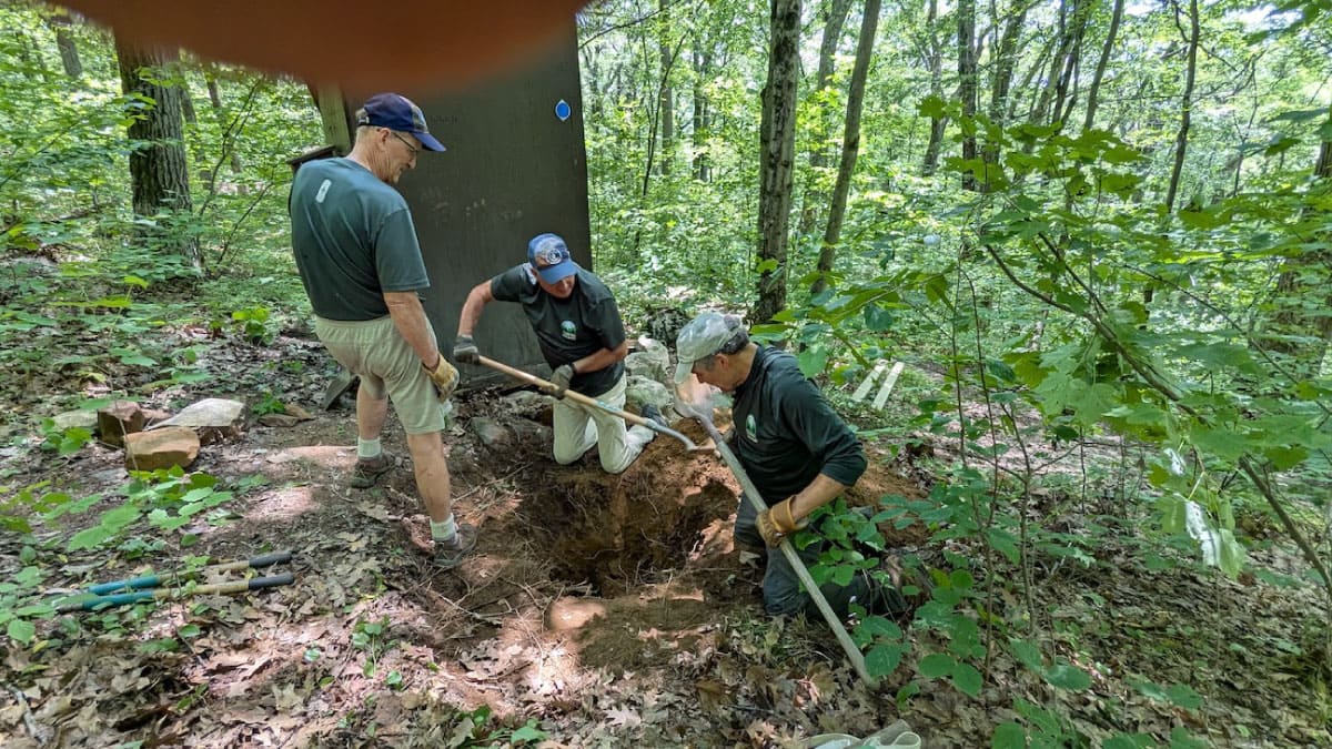 Workers maintaining campsite privies