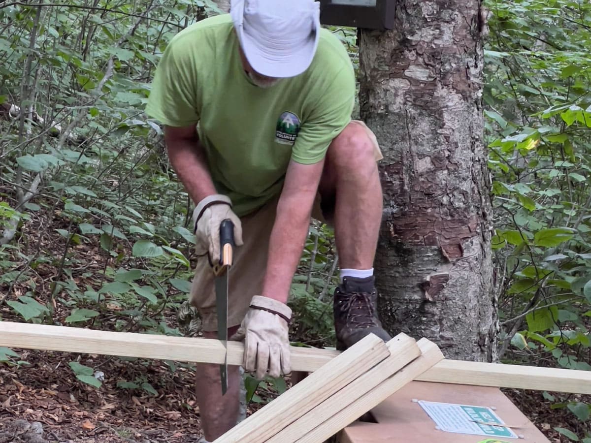 A worker sawing lumber